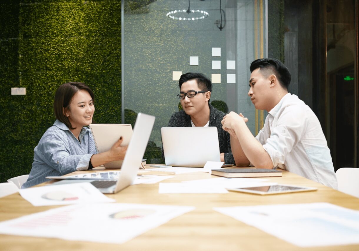 coworkers discussing ideas from paper for start-ups